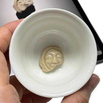 Ceramic cup with smiling face and facial pattern roof tile design